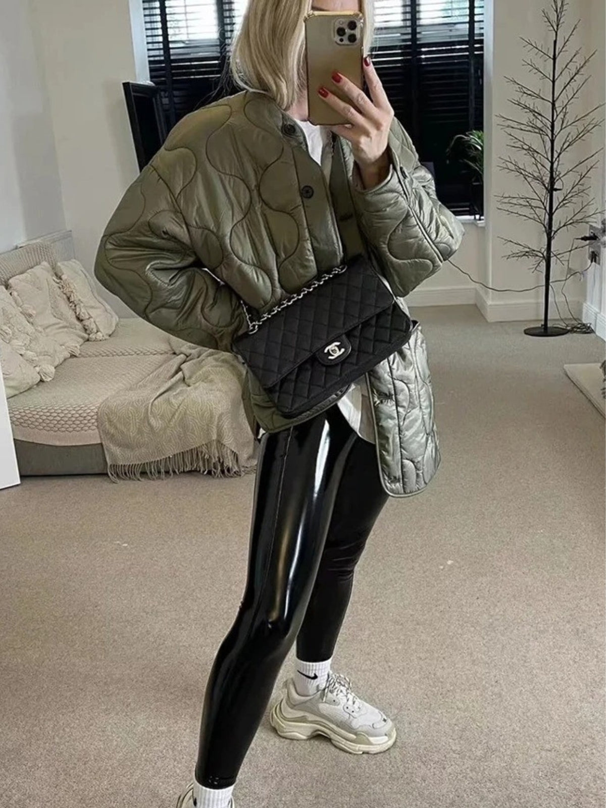 Green quilted jacket with wave stitching worn with leggings and sneakers, side view