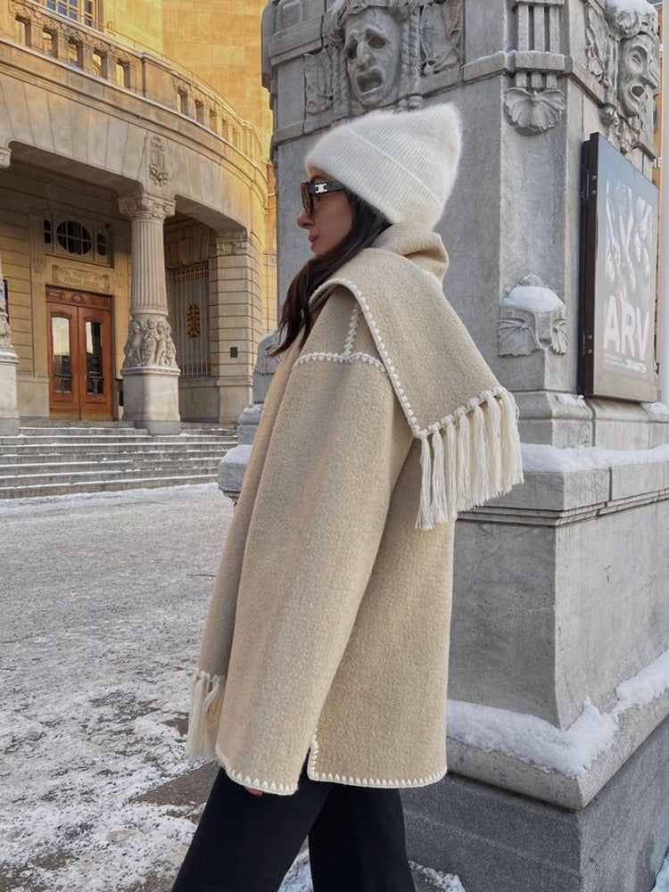 Beige scarf wrap coat with the scarf over the shoulder, side view