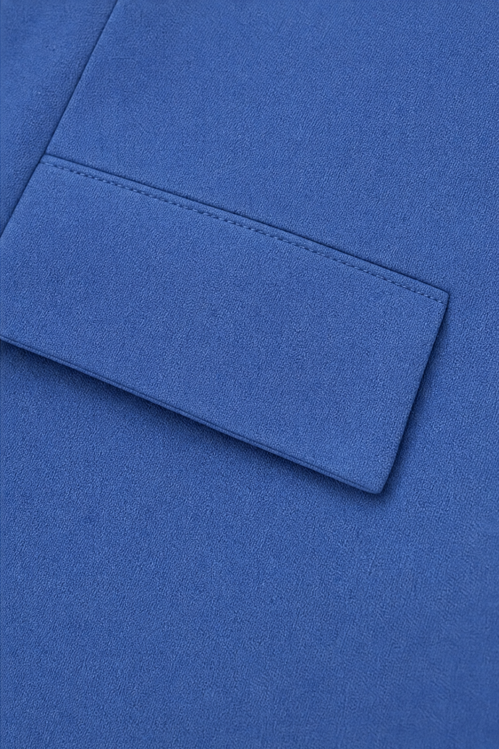 Welt pocket detail on a blue roll sleeve blazer