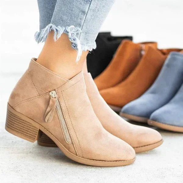 Beige suede ankle boots with the other colourways behind them