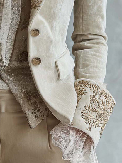 Close-up of the embroidered cuff and two-button front of the ivory blazer