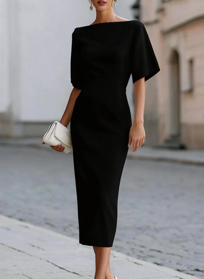 Black boat neck midi pencil dress with dolman sleeves and a white clutch