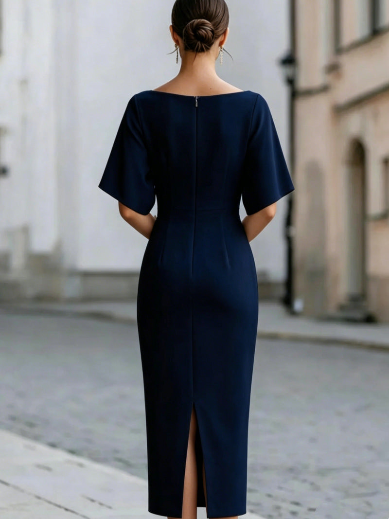 Back of a navy midi pencil dress with a center back zip and a back slit