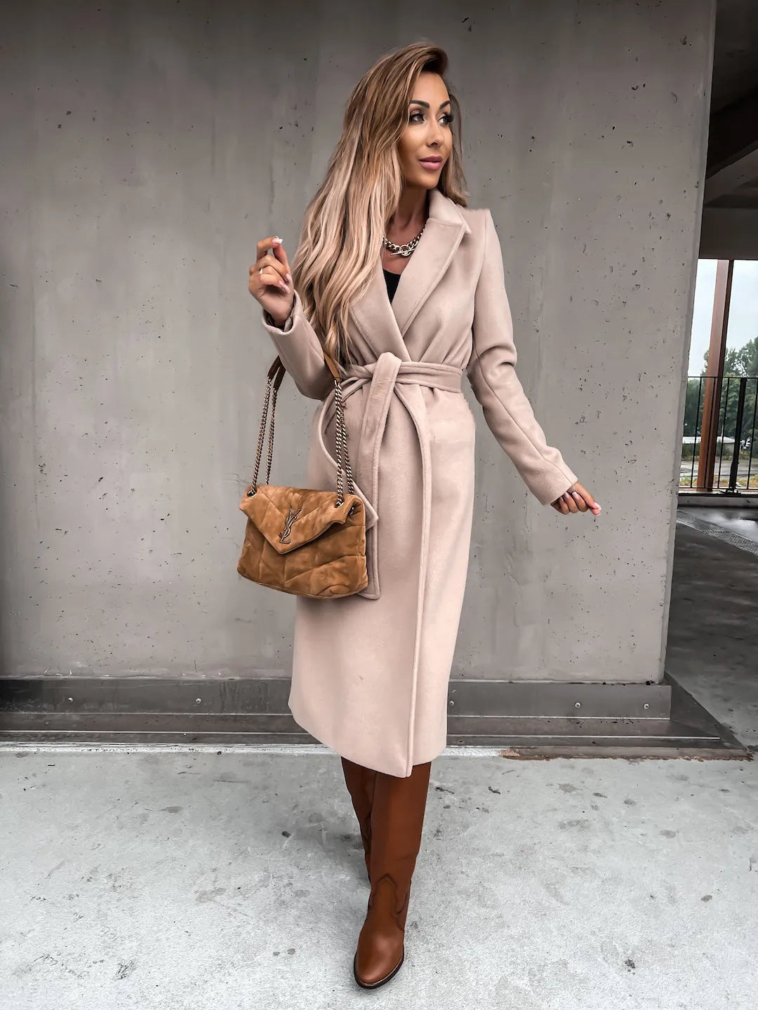 Beige belted shawl collar coat worn with brown boots