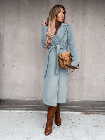 Light blue belted shawl collar coat worn with brown boots