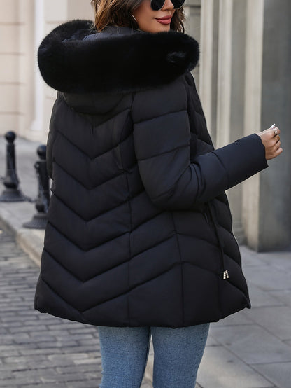 Black quilted coat seen from the side with the fur hood up