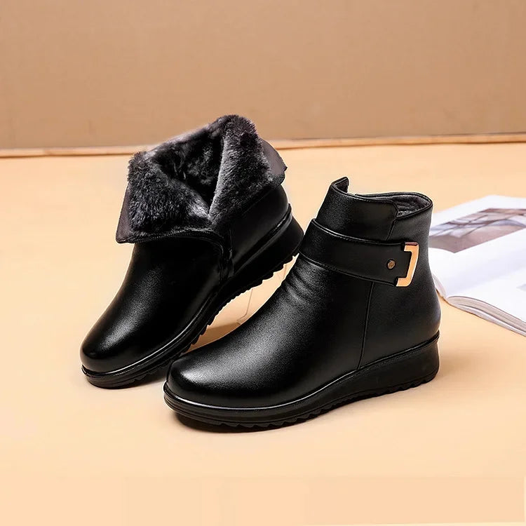 Pair of black ankle boots with a buckle strap, one folded open to show the plush lining