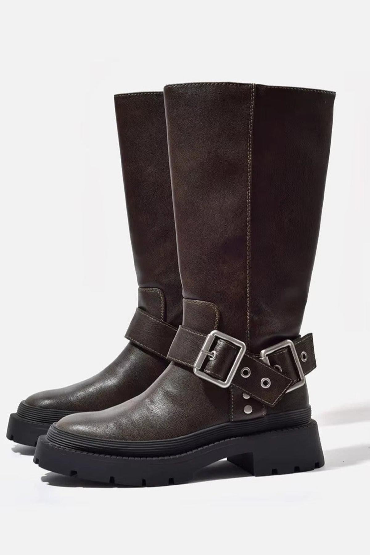 Brown knee-high biker boots with double buckle straps and a black lug sole, front side view