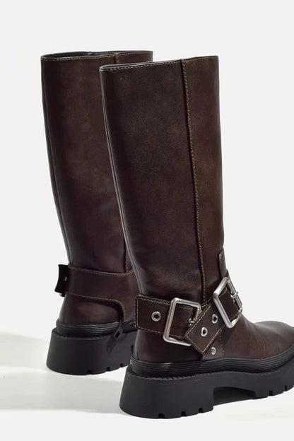 Brown biker boots from behind, showing the buckled ankle straps and chunky sole