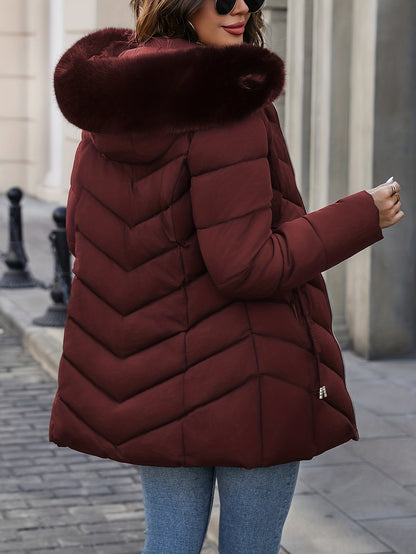 Burgundy quilted coat seen from the side with the fur hood up