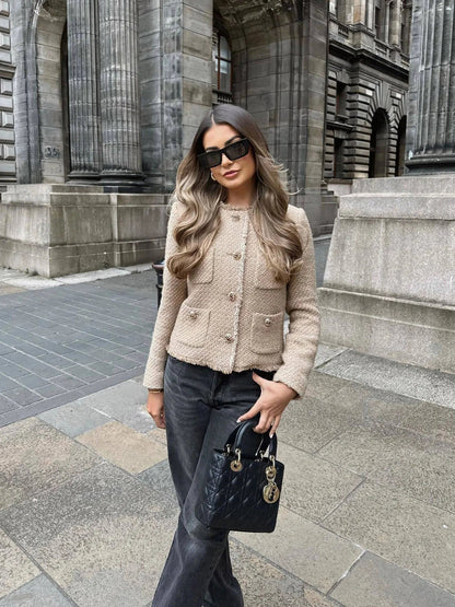 Beige tweed jacket buttoned up and worn with black leather pants