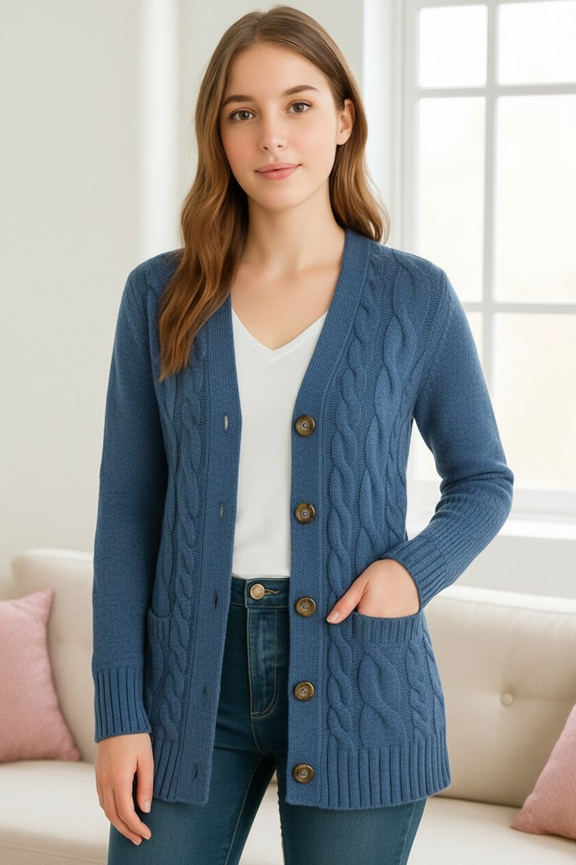 Woman wearing a blue cable knit longline cardigan over a white tee with jeans, front view