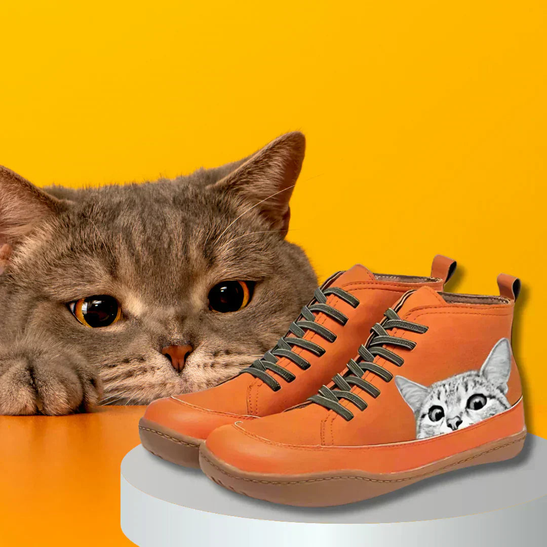 Orange cat print ankle boots next to a real cat