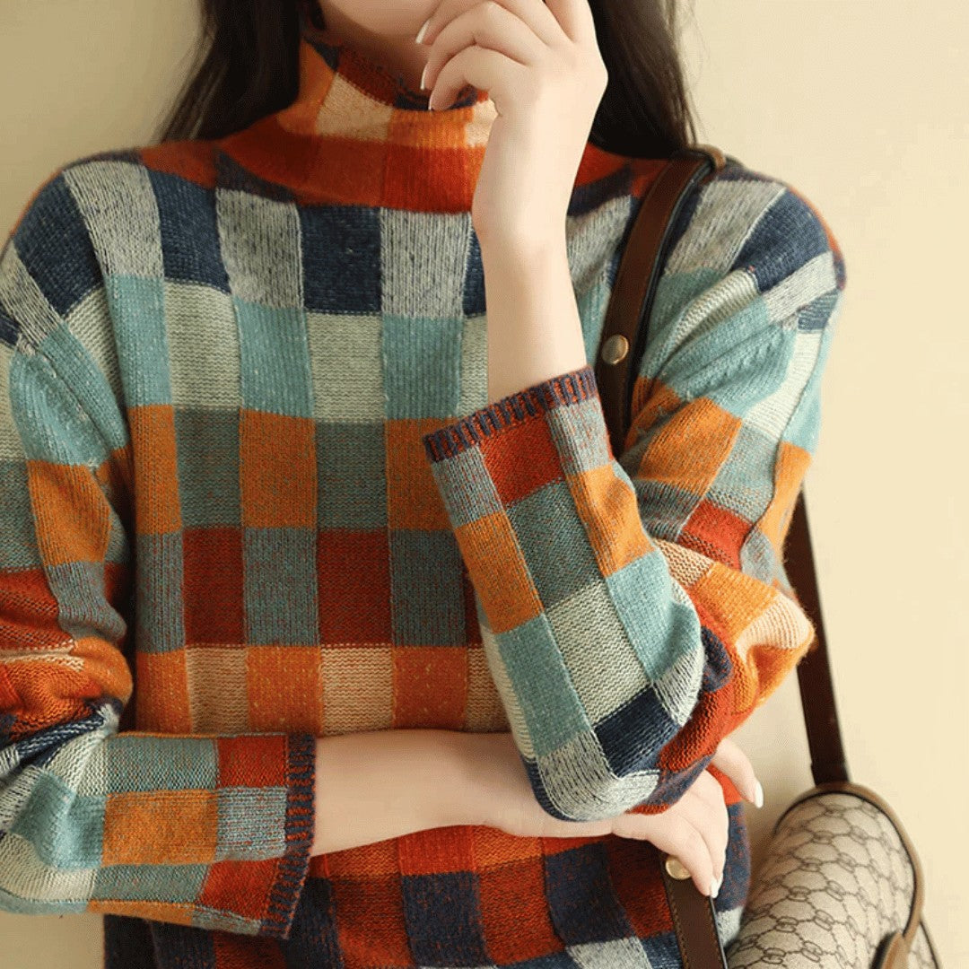 Checkerboard knit turtleneck worn with a shoulder bag