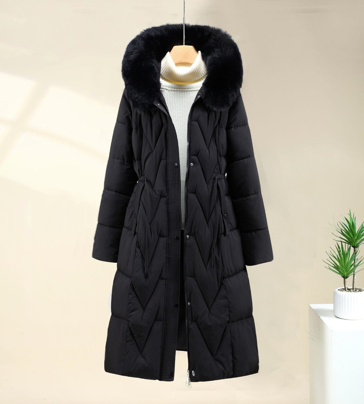 Black long parka with faux fur hood worn open over a white top