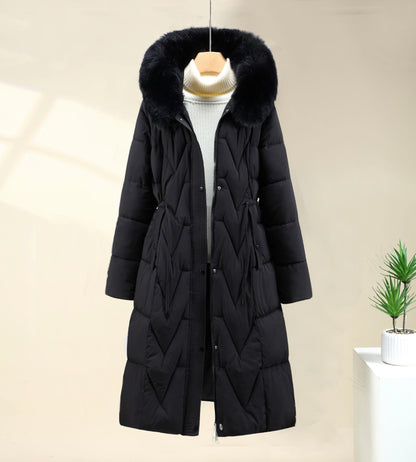 Black long parka with faux fur hood worn open over a white top