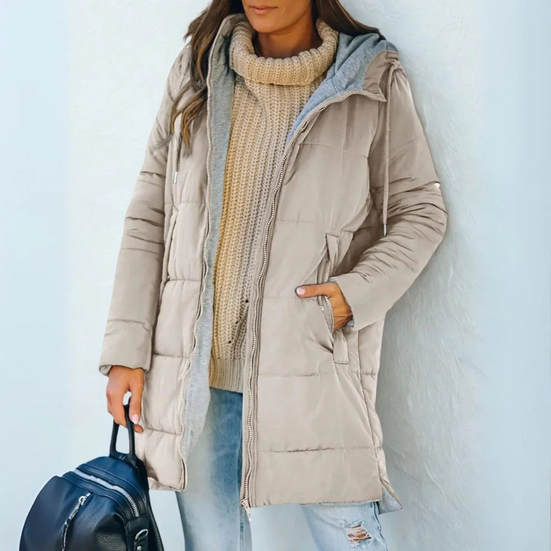Beige quilted hooded coat worn open over a knit sweater, front view
