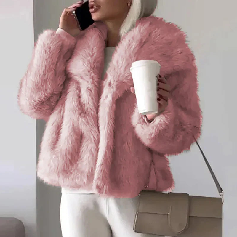 Pink cropped faux fur jacket worn with a bag