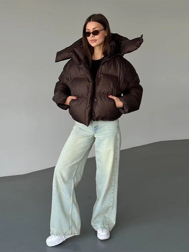 Dark brown cropped hooded puffer worn with jeans