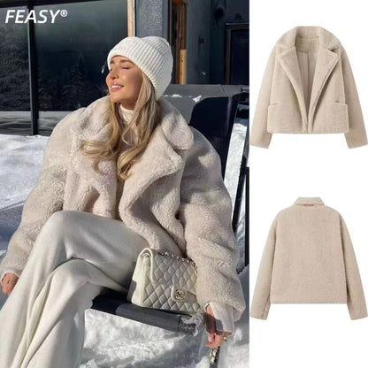 Beige cropped teddy jacket worn with cream pants in the snow