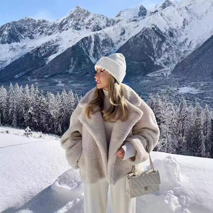 Beige cropped teddy jacket worn in a snowy mountain setting