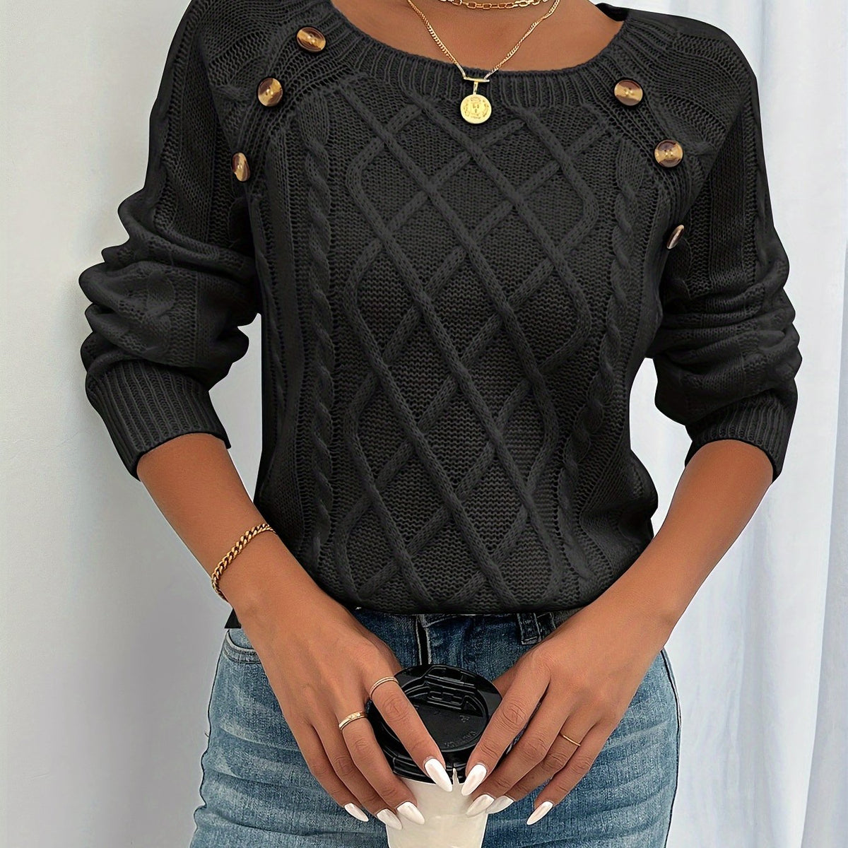 Black cable knit sweater with button trim worn with jeans