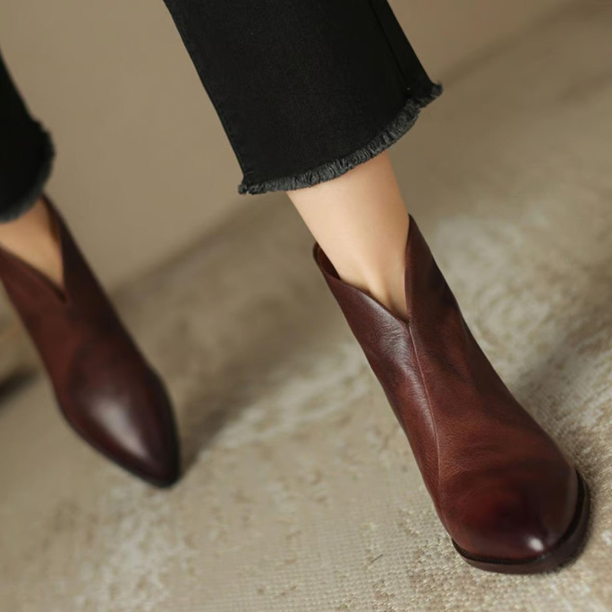 Wine V cut ankle boots on foot, front view