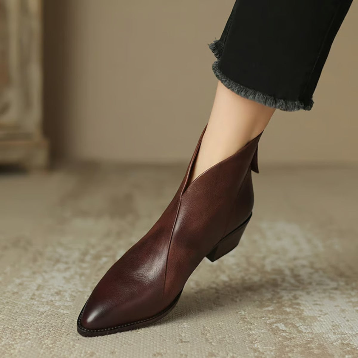 Wine V cut ankle boot on foot, side view of the low heel