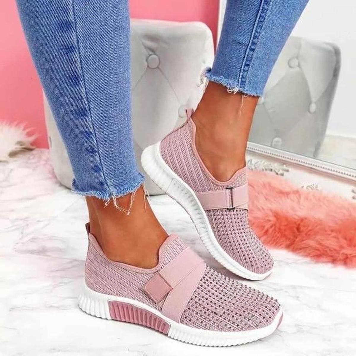 Pink elastic strap sneakers with a studded toe and white sole, worn with cropped jeans