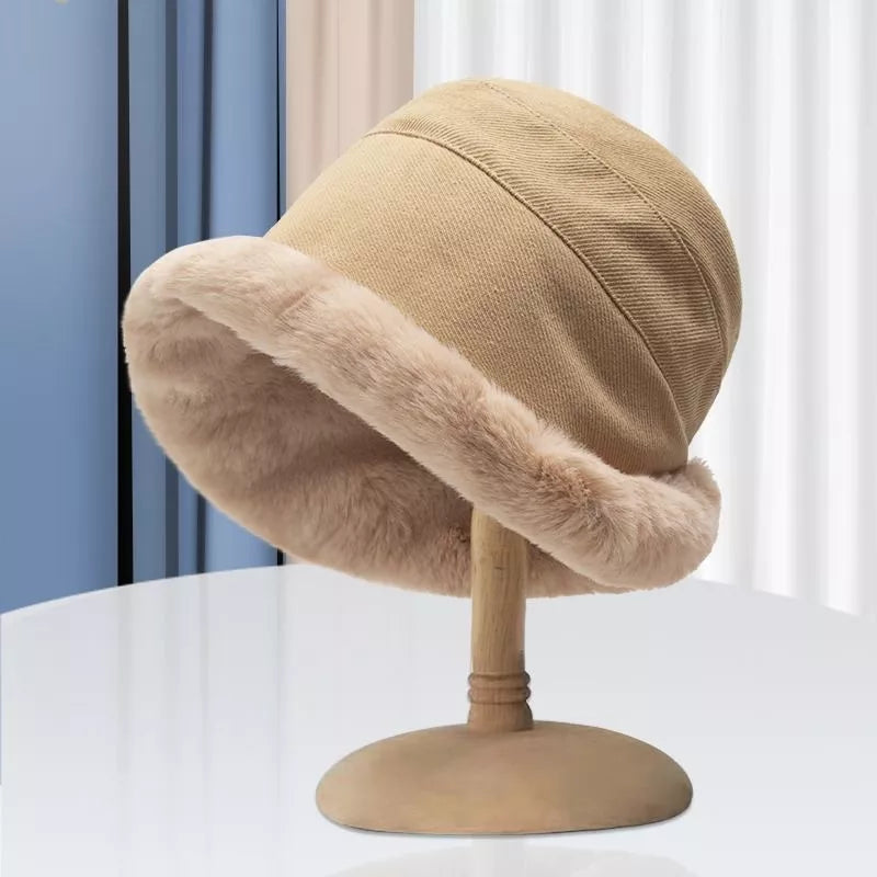 Beige bucket hat with a faux fur brim on a hat stand