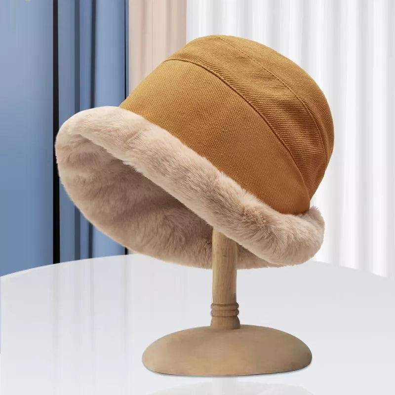 Mustard bucket hat with a faux fur brim on a hat stand