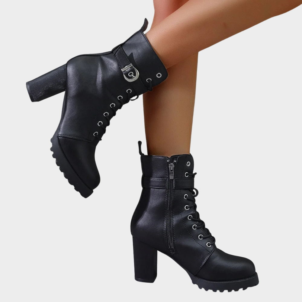 Black combat boots with a buckle strap worn walking