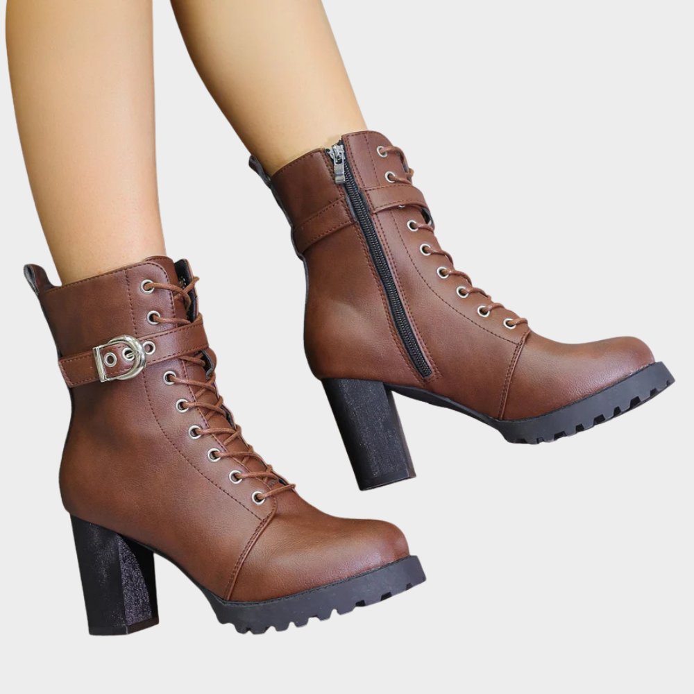 Brown combat boots with a buckle strap and lug sole