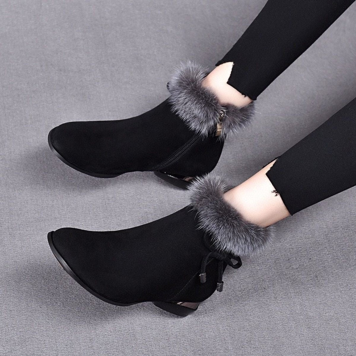 Black fur cuff booties with side bow, worn with leggings