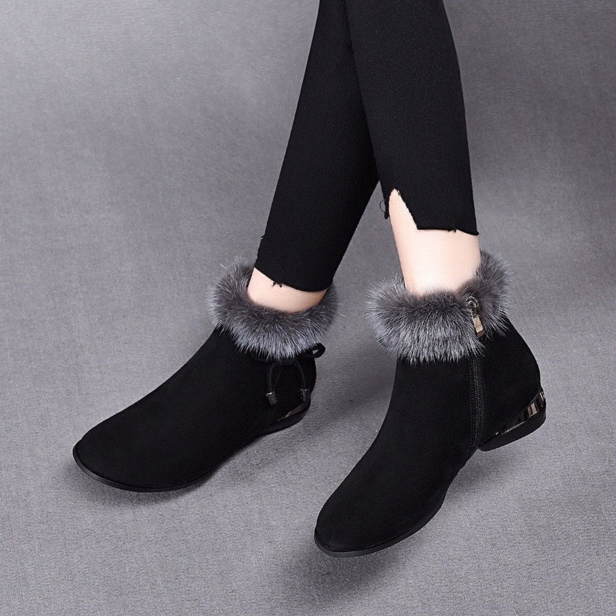 Black suede ankle booties with faux fur trim, worn