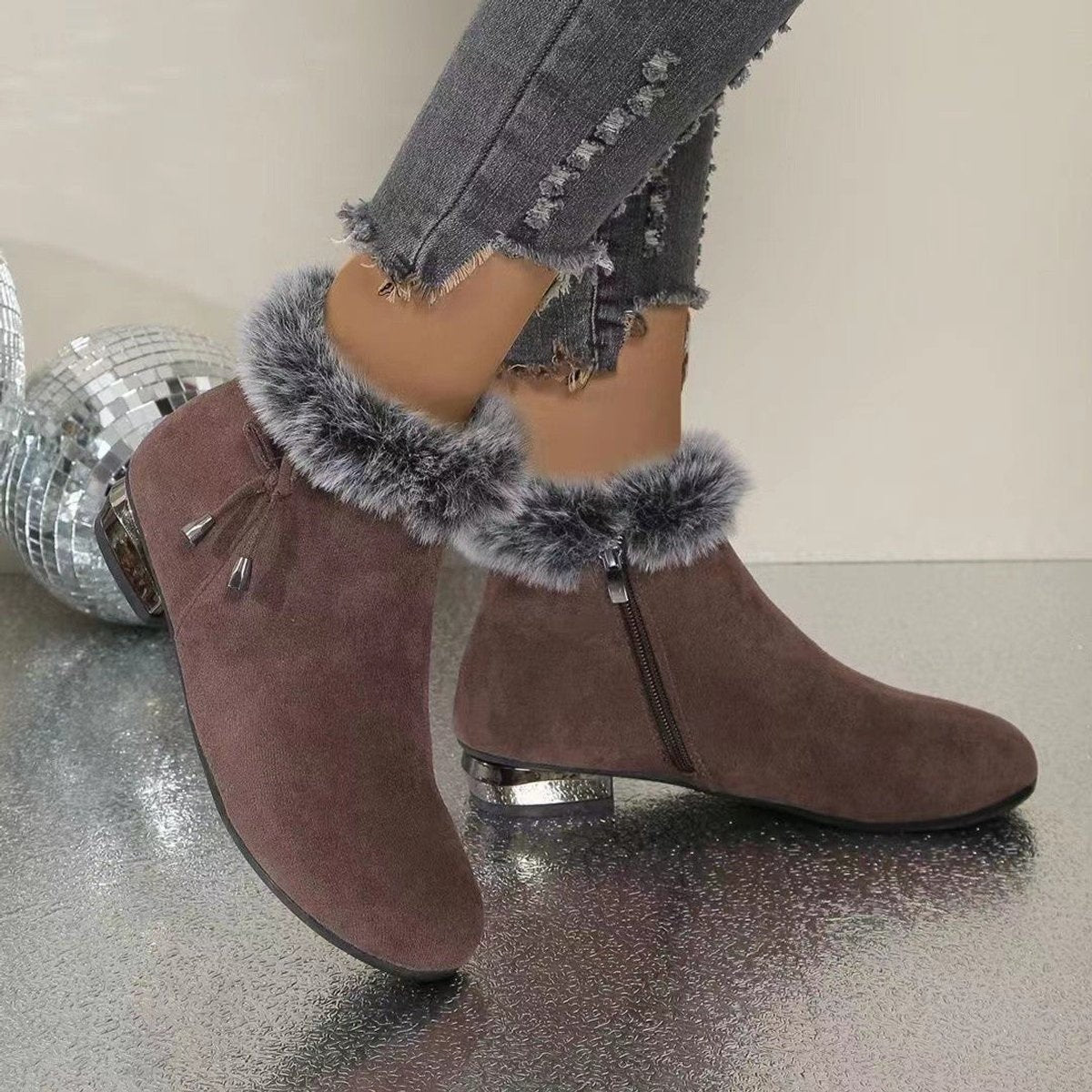 Brown suede booties with bow detail and metallic heel, worn