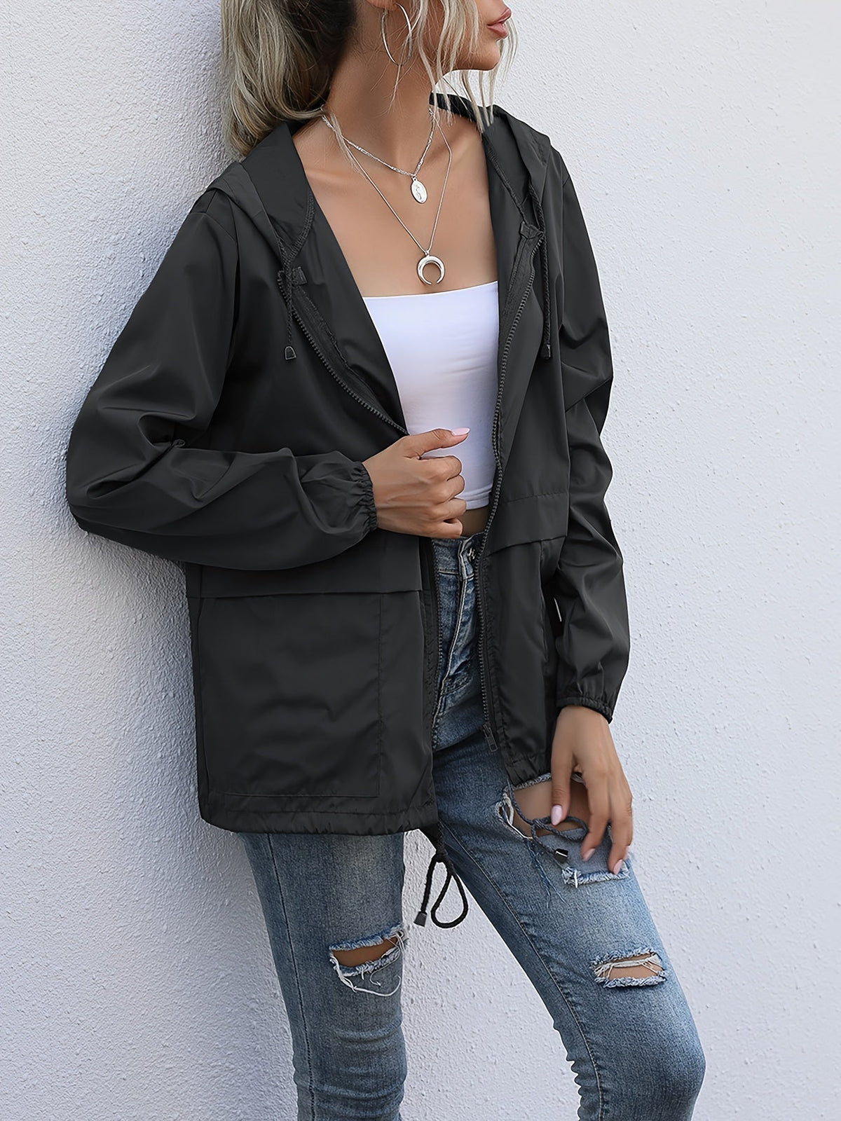 Black hooded windbreaker worn open with ripped jeans