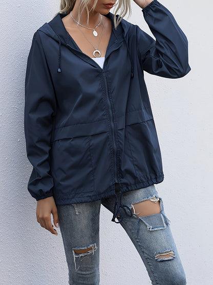 Navy hooded windbreaker with a drawcord hem worn with ripped jeans