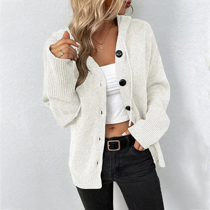 White hooded knit cardigan worn over a crop top and dark jeans, front view