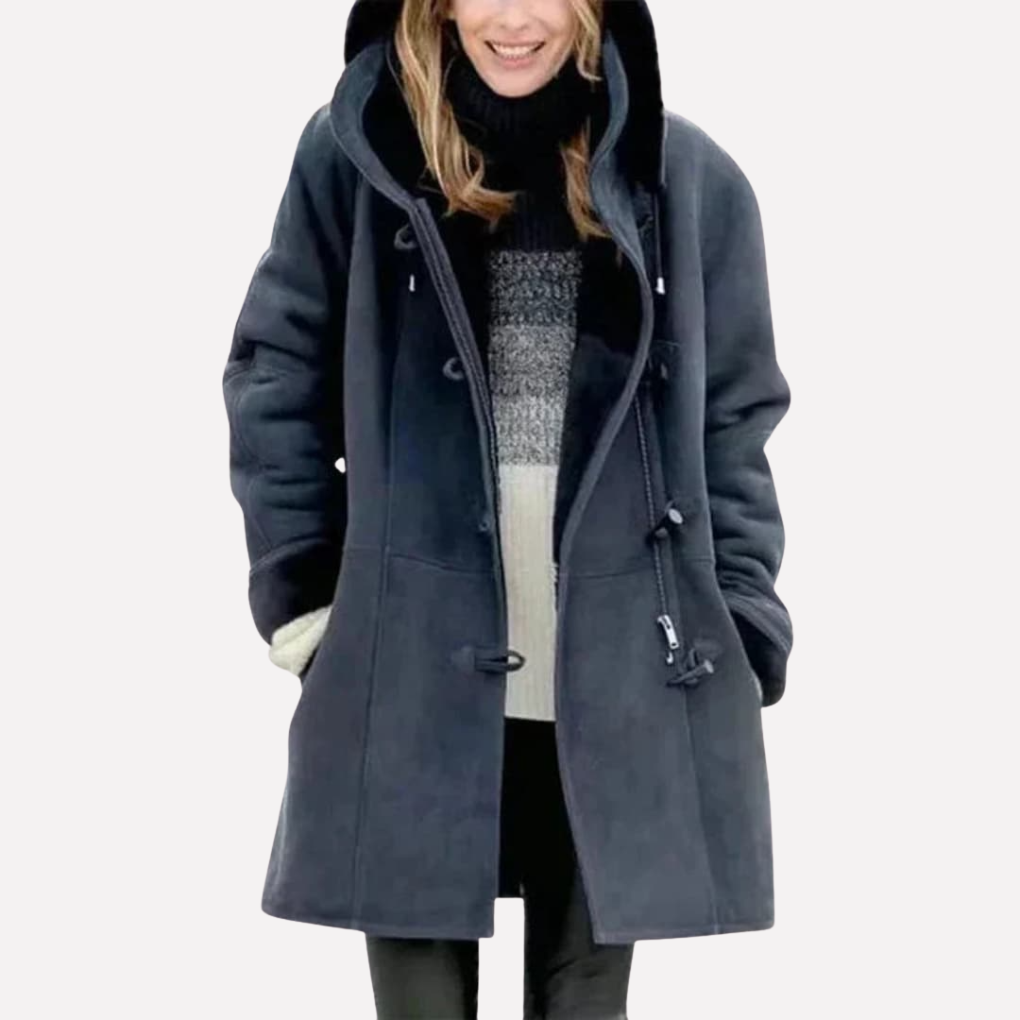 Slate blue hooded toggle front coat worn with a patterned sweater