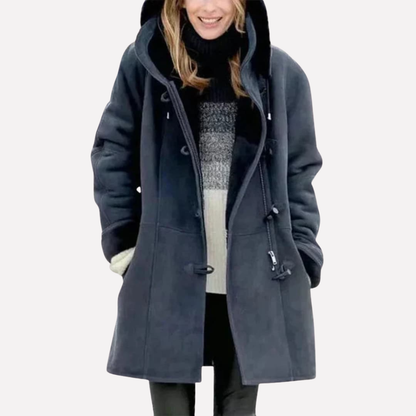 Slate blue hooded toggle front coat worn with a patterned sweater