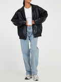 Black oversized collared bomber jacket worn open over a white top and jeans, front view