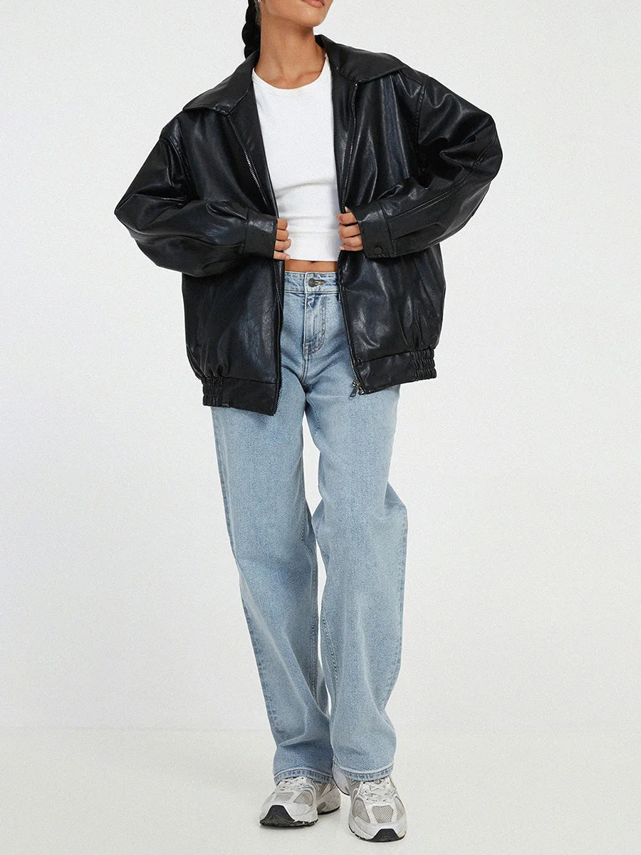 Black oversized collared bomber jacket worn open over a white top and jeans, front view