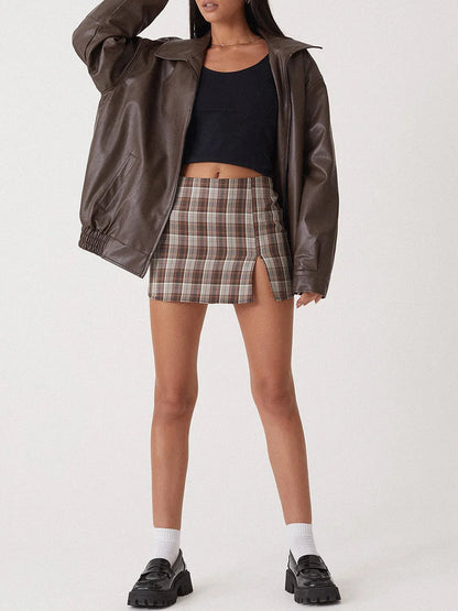 Brown oversized collared bomber jacket worn over a plaid mini skirt, front view