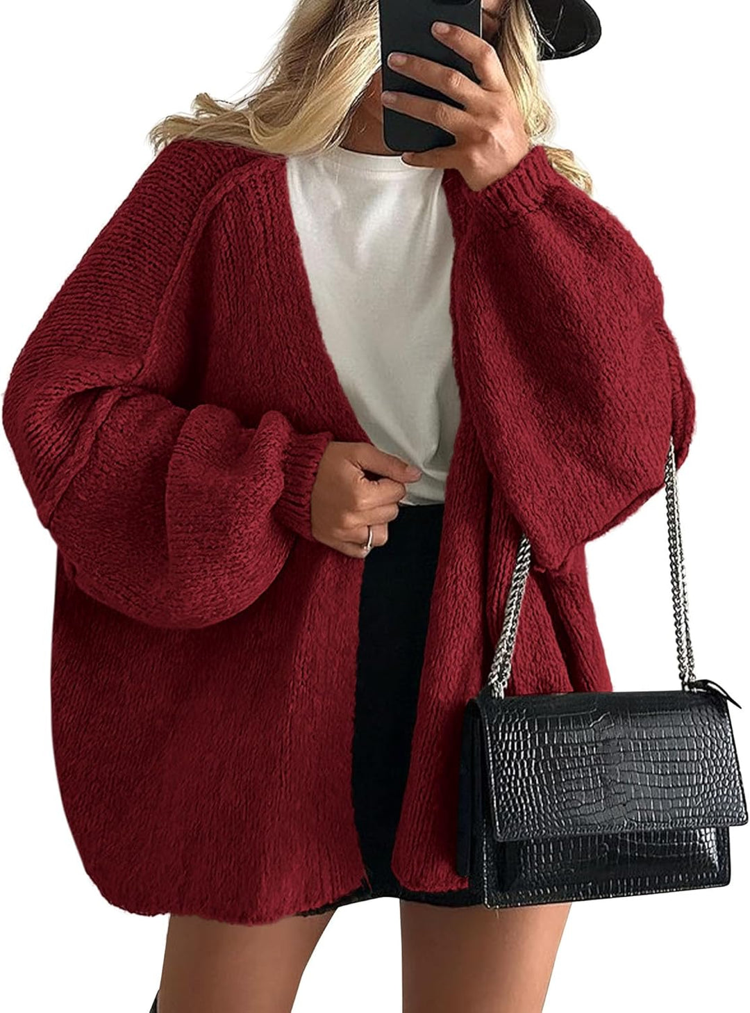 Woman in a burgundy oversized open front cardigan with balloon sleeves over a white tee