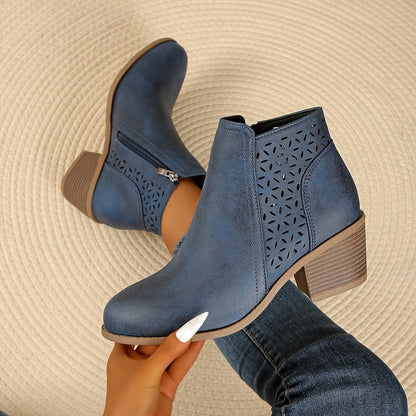 Denim blue perforated panel ankle boots held up, side view