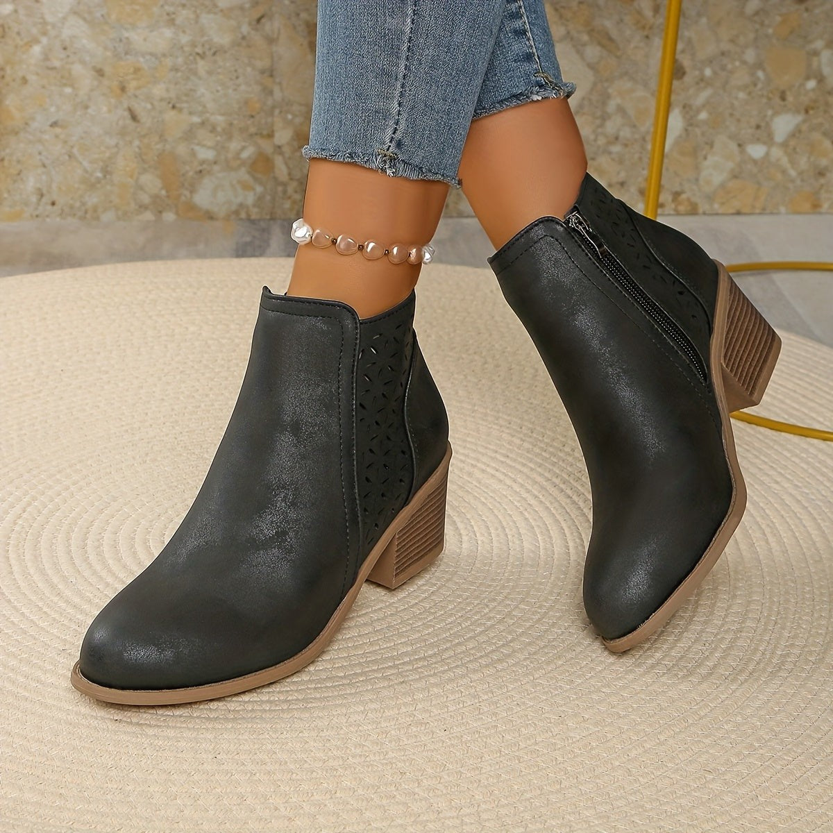 Gray perforated panel ankle boots worn with jeans, front view