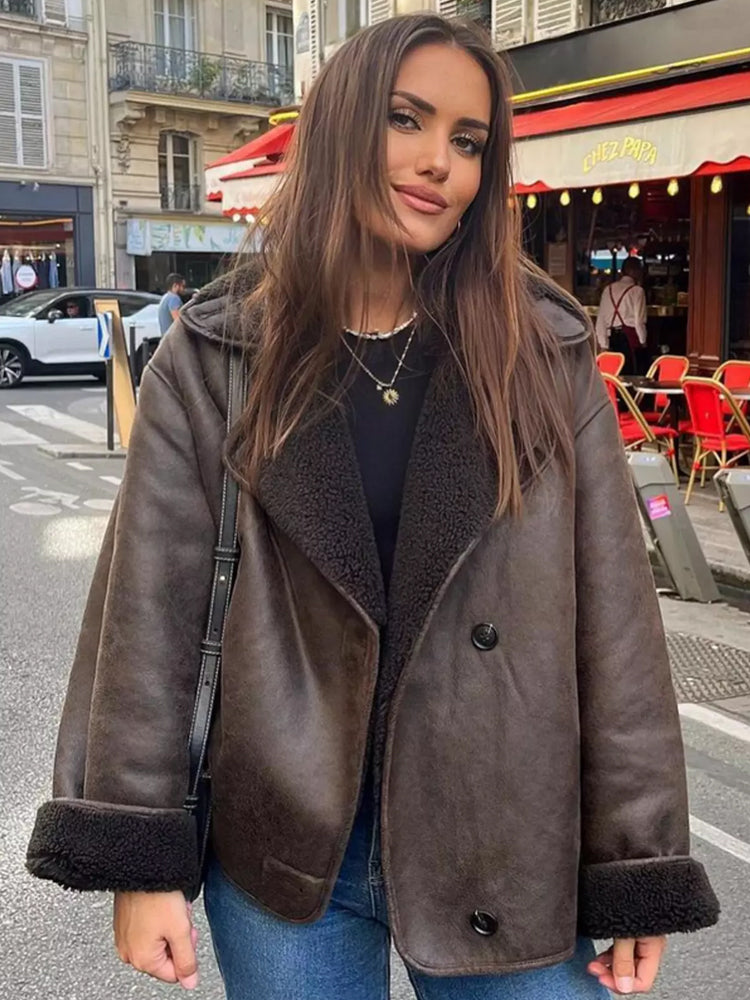 Brown relaxed lapel jacket worn open over a black top on a city street, front view