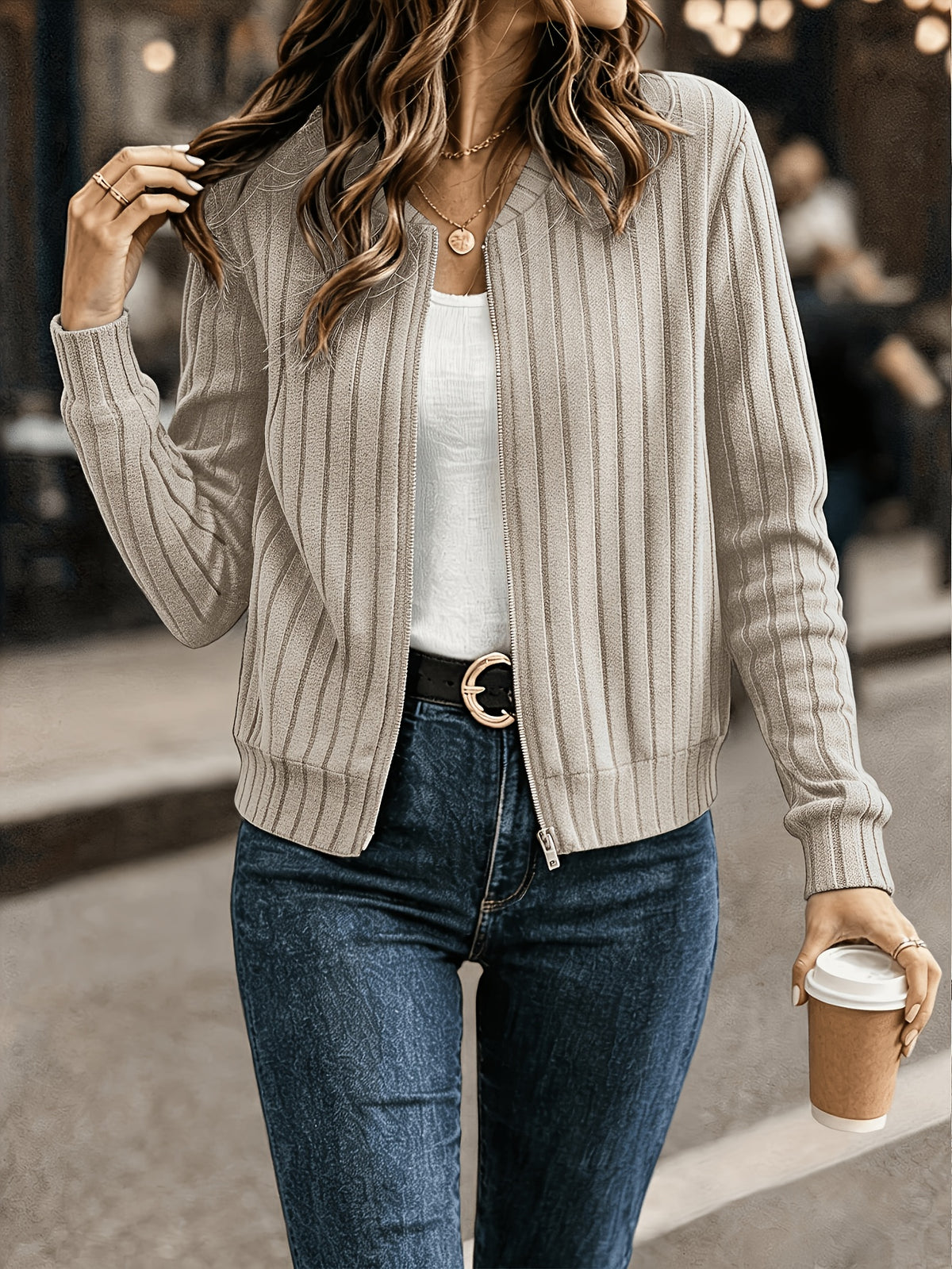 Beige ribbed knit zip front jacket worn open with jeans
