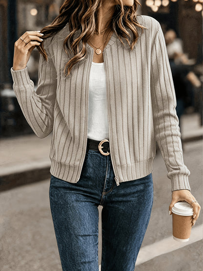 Beige ribbed knit zip front jacket worn open with jeans